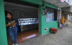 An electricity generator is seen outside a shop during the energy rationing in Quito. AFP/Rodrigo Buendia