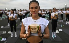 A yoga enthusiast holds a coconut during the sunrise yoga event