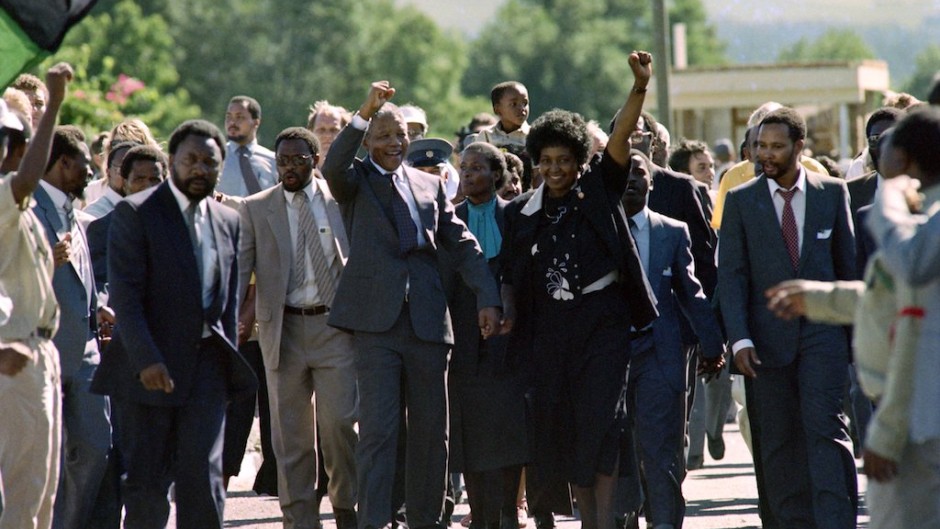 Nelson Mandela (C) and anti-apartheid campaigner Winnie Madikizela-Mandela raising their fists and saluting cheering crowds upon Mandela's release from the Victor Verster prison near Paarl.