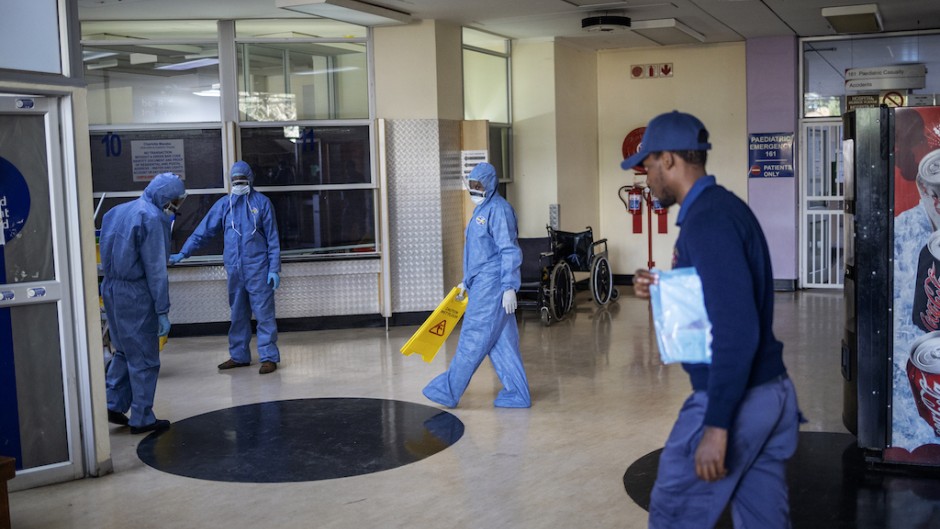 Workers wearing protective clothing clean an entrance hall of the Charlotte Maxeke Hospital in Johannesburg.