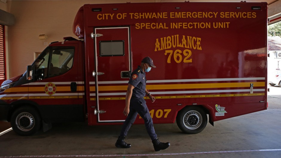 Members of the Tshwane Special Infection Unit on COVID-19 coronavirus walks past the Infectious Unit Ambulance during their demonstration exercise at the Hatfield Emergency Station in Pretoria on May 4, 2020.