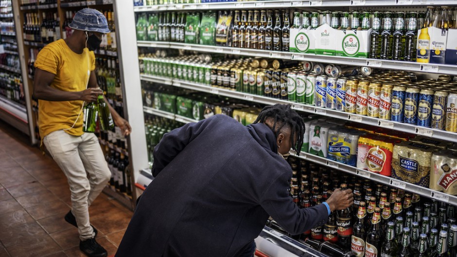 Customers buy alcohol at a liquor shop at the Bara taxi rank in Soweto, Johannesburg.