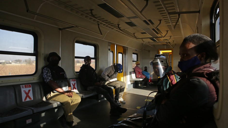 File: Commuters wearing face masks sit apart from each other to maintain social distancing inside a train outside the Pienaarspoort Station as the Passenger Rail Agency of South Africa (PRASA) resumes its operations near Pretoria on July 1, 2020. Phill Magakoe / AFP