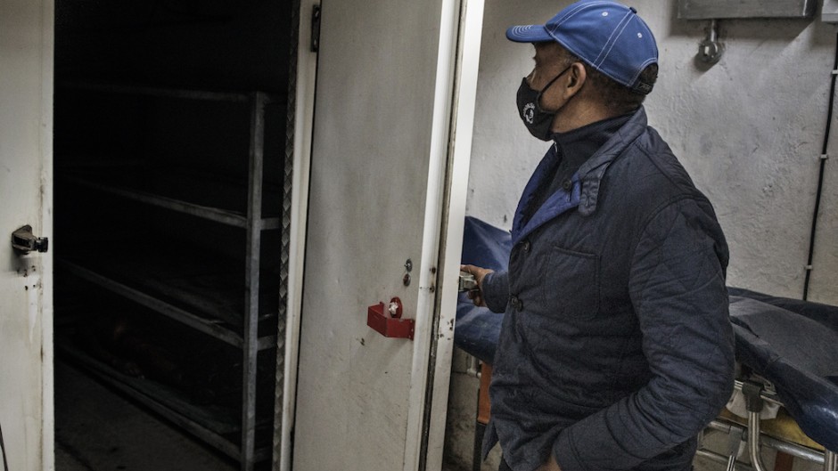 Sello Headbush, the owner of a Funeral Parlourh opens the door of his cold storage facility to check the situation during a load shedding in Port Elizabeth on July 11, 2020.