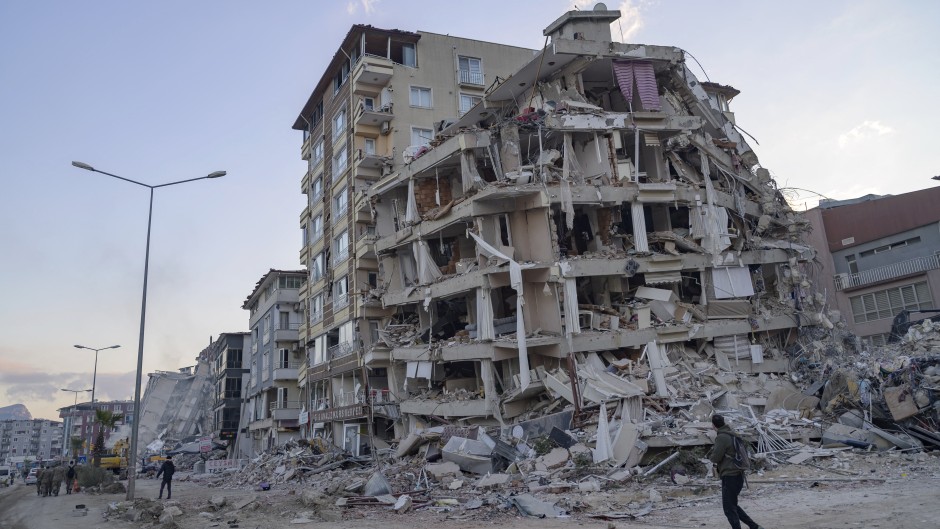 File: A man looks up at a collapsed building in Hatay, southern Türkiye on February 19, 2023. Yasin AKGUL / AFP