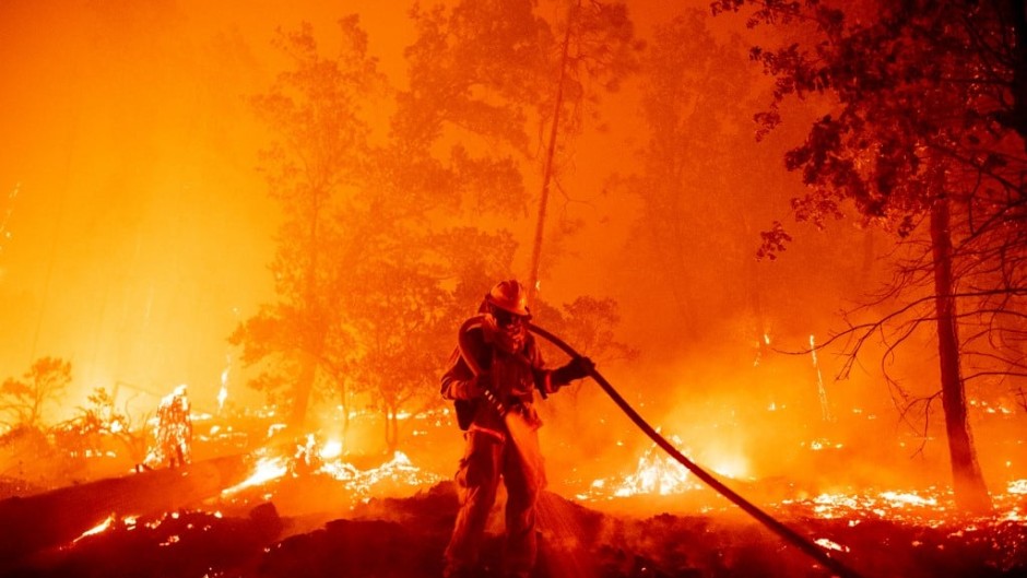 A firefighter douses flames as they push towards homes during the Creek fire in the Cascadel Woods area of unincorporated Madera County, California on September 7, 2020. 