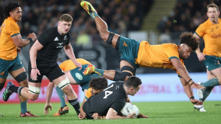 New Zealand's Will Jordan is tackled as Australia's Rob Valentini dives over the top during the rugby test match at Eden Park in Auckland