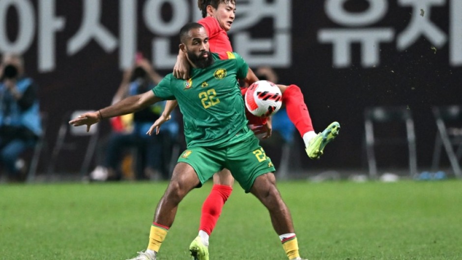 South Korea's Kim Jin-su (top) fights for the ball with Cameroon's Bryan Mbeumo in Seoul