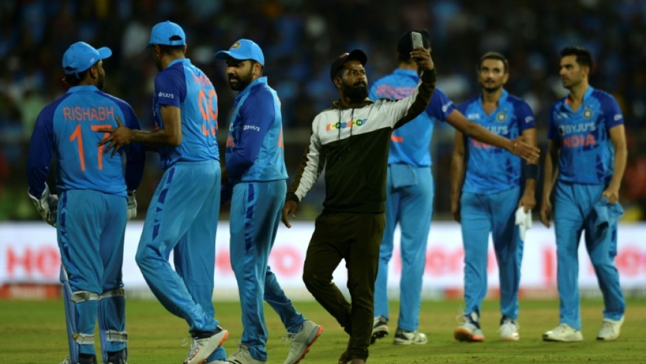 Unwanted intrusion: A pitch invader takes a selfie with India players 