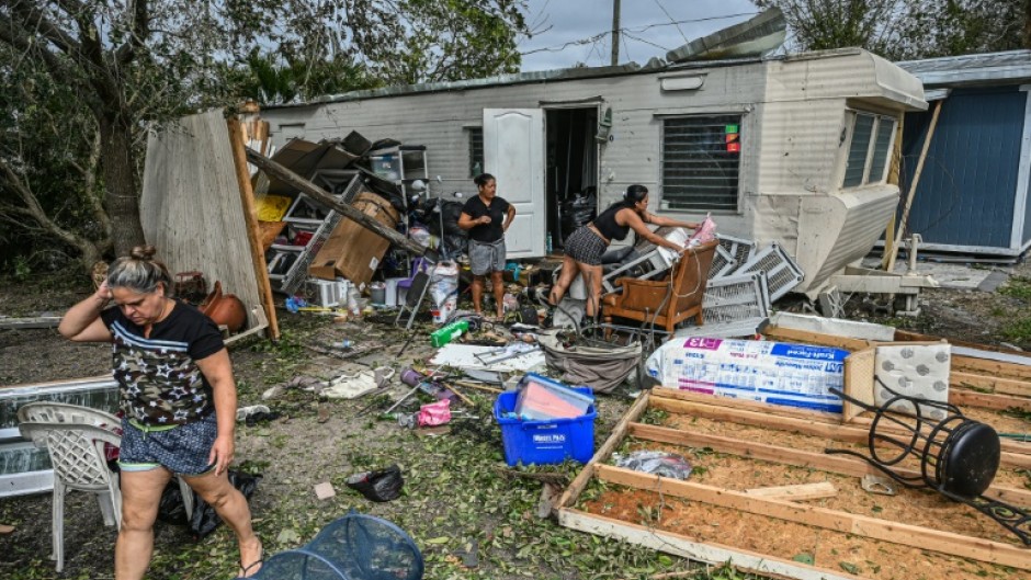 A woman carries her belongings down a flooded street in the Orlovista neighborhood following Hurricane Ian on October 1, 2022 in Orlando, Florida