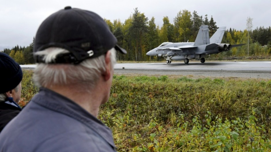 A Finnish air force fighter jet lands on a highway