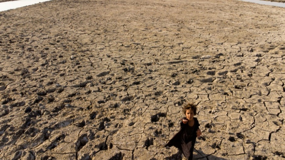 A child walks on the dried-up bed of Iraq's receding southern marshes of Chibayish in Dhi Qar province on August 23, 2022