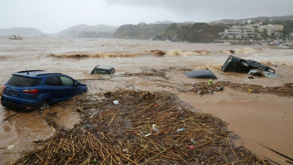 Cars are carried away by floods at the beach of the popular resort of Agia Pelagia, on the southern Greek island of Crete, following flash floods on October 15, 2022