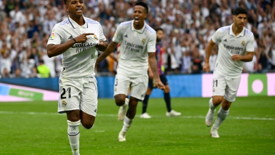 Real Madrid's Brazilian forward Rodrygo (L) celebrates after scoring his team's third goal against Barca