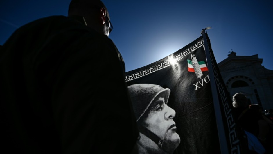 A participant holds a flag during a rally marking the centenary of the March on Rome which ushered in fascism