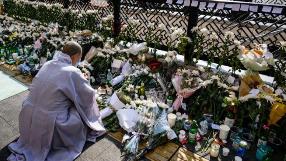 At a makeshift memorial close to the narrow alleyway at the epicenter of the disaster, Buddhist monks chanted prayers for the dead