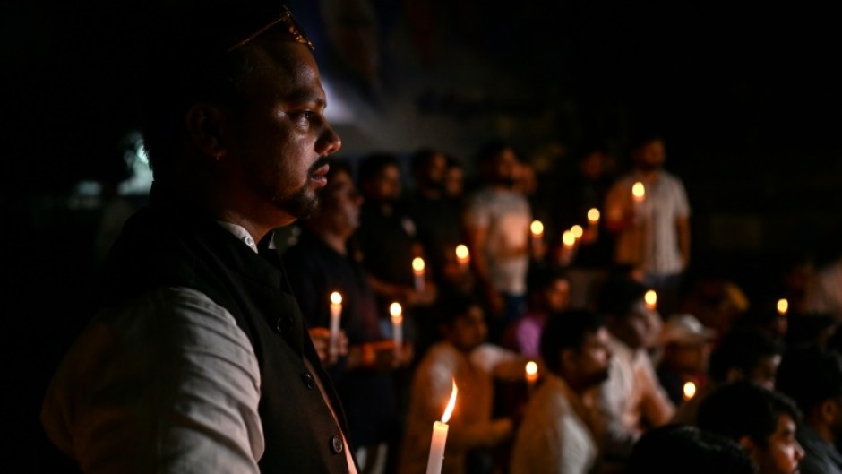 Members of India's Youth Congress take part in a candlelight vigil in New Delhi on Monday for victims of the bridge collapse