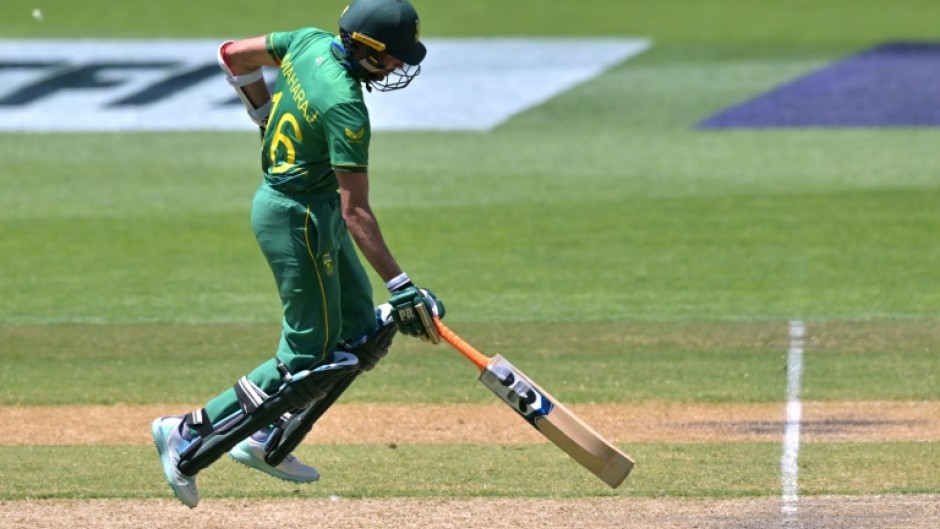 The Netherlands' Tom Cooper plays a shot over the boundary line for six runs watched by South Africa's wicketkeeper Quinton de Kock (L) during their men's Twenty20 World Cup match