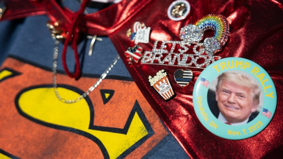 A supporter wears pins supporting former US president Donald Trump while arriving at a rally in Vandalia, Ohio, on November 7, 2022 -- the eve of US midterm elections