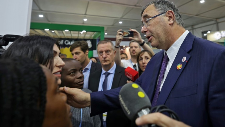 Total Energies CEO Patrick Pouyanne (R) speaks with activists at the COP27 UN climate conference where he was heckled by others angered by the presence of fossil fuel lobbyists