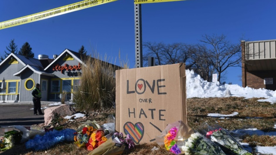 Bouquets of flowers and a sign reading "Love Over Hate" are left near Club Q following the mass shooting