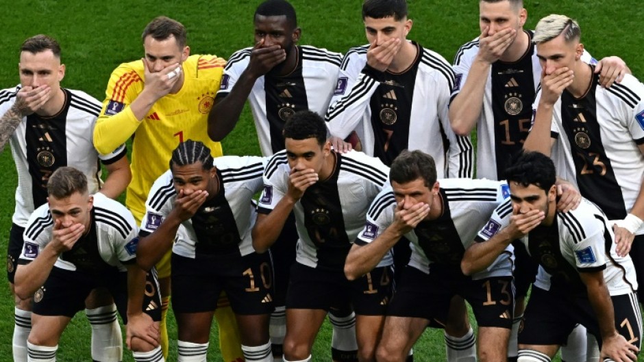 Germany's players cover their mouths as they pose for a picture before their World Cup opener