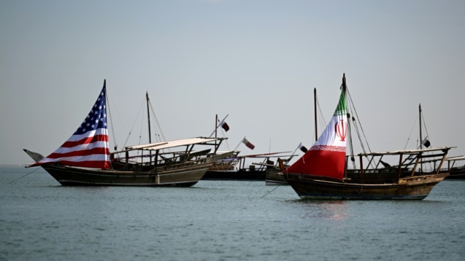 Traditional Qatari dhow boats fly the US and Iranian flags off the coast of Doha