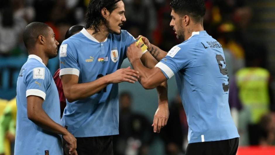 Luis Suarez (right) passes on the captain's armband to substitute Edinson Cavani at the World Cup