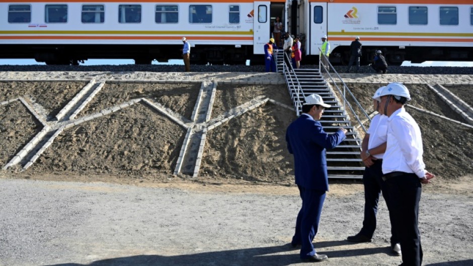 Chinese builders stand next to the Standard Gauge Railway train at Mai Mahiu, Kenya, in October 2019