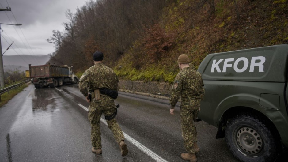 NATO soldiers in the Kosovo peacekeeping mission (KFOR) inspect a road barricade set up by ethnic Serbs