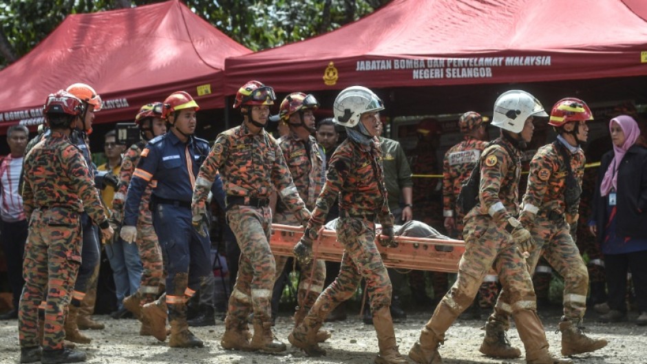 Rescue workers scoured muddy terrain for survivors and bodies as the death toll from a landslide at a Malaysian campsite rose to 24