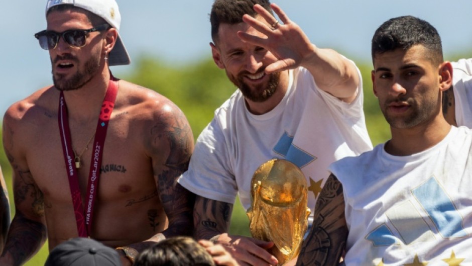 Lionel Messi (centre) celebrates Argentina's World Cup victory alongside team-mates Rodrigo de Paul (left) and Cristian Romero (right) in Buenos Aires before Christmas