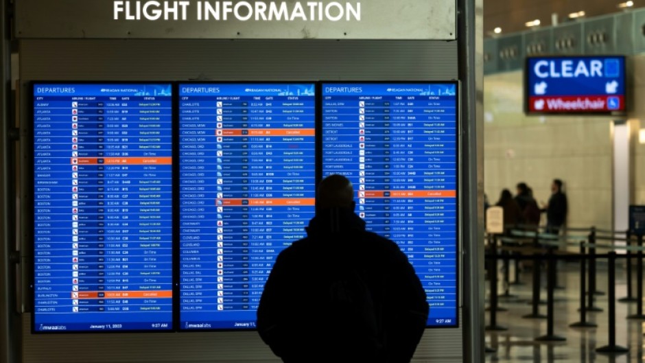 A traveler looks at a display listing cancelled and delayed flights at Ronald Reagan National Airport in Virginia on January 11, 2023