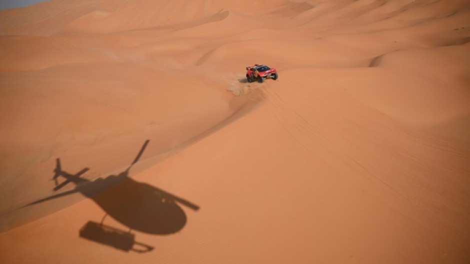 Sebastien Loeb and Belgian co-driver Fabian Lurquin steer their BRX to victory tracked by a helicopter in Saudi Arabia's Empty Quarter