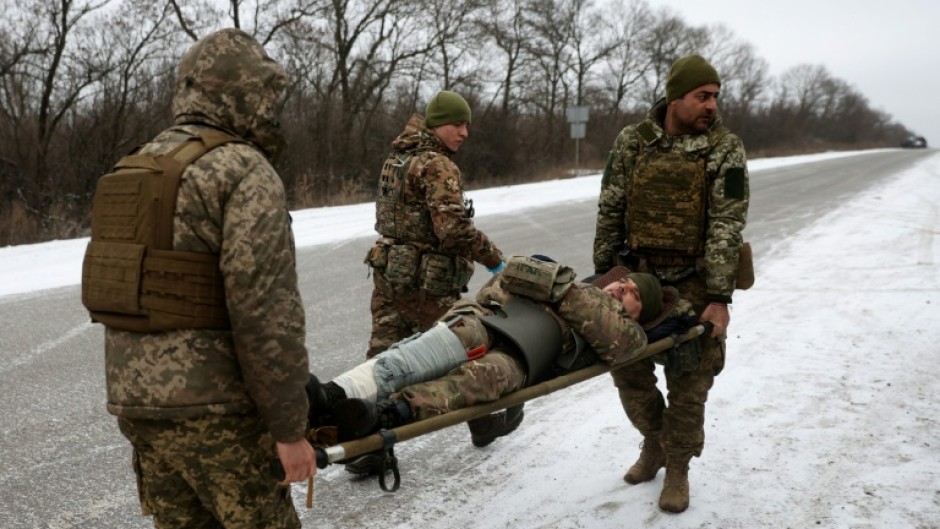 Ukraine army medics evacuate a wounded soldier on a road not far of Soledar on Saturday