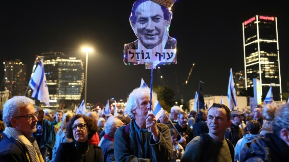 A protester holds up a caricature of Prime Minister Benjamin Netanyahu, whose return to power last month has seen a series of moves to boost the power of politicians over the courts