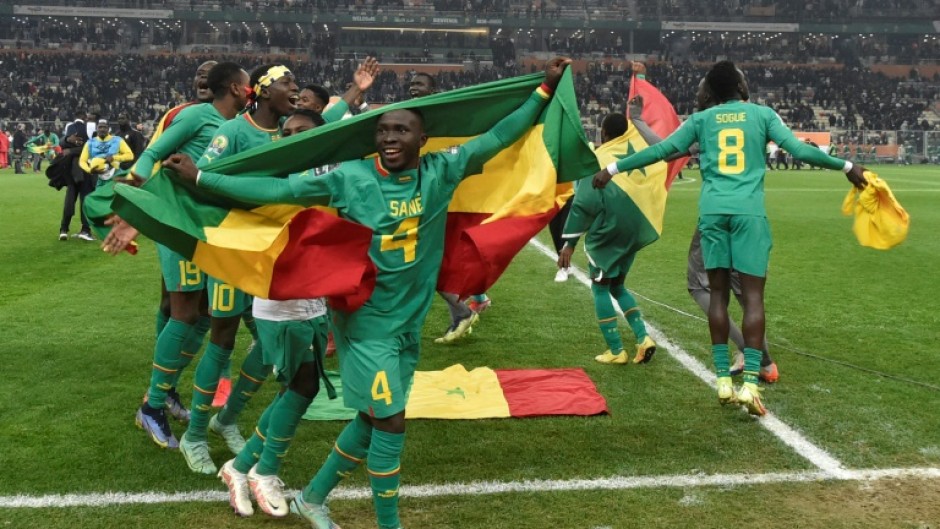 Final flourish: Senegal defender Mamadou Sane celebrates with the national flag after Saturday's final