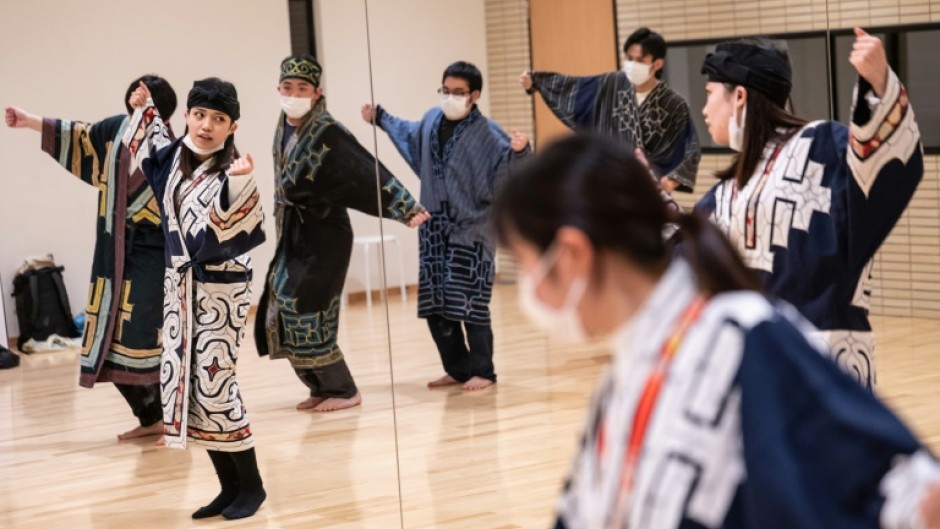 Indigenous student Mizuki Orita (2nd L) practices a traditional dance with members of the Ainu culture club Sapporo University