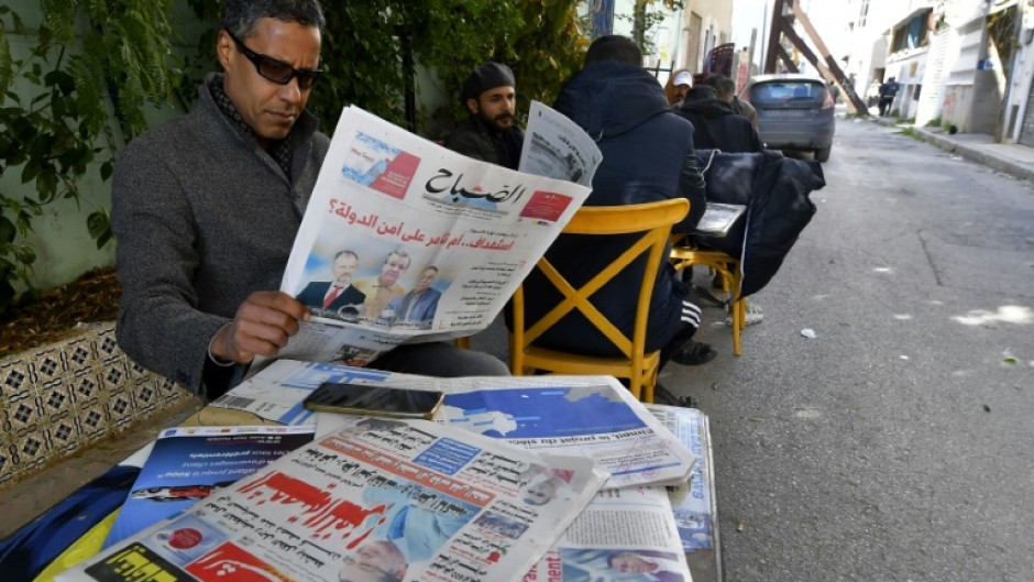 A man in Tunis reads the latest news after a wave of arrests that has targeted activists, former lawyers and a prominent businessman