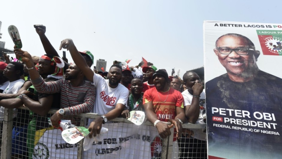 Supporters chant party slogans next to a banner of the candidate of the Labour Party Peter Obi during a campaign rally of the party in Lagos, on February 11, 2023.