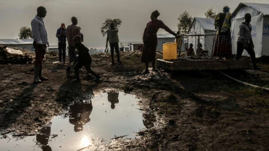 People queue for water at the Bushagara camp for displaced people, north of the eastern DR Congo city of Goma 