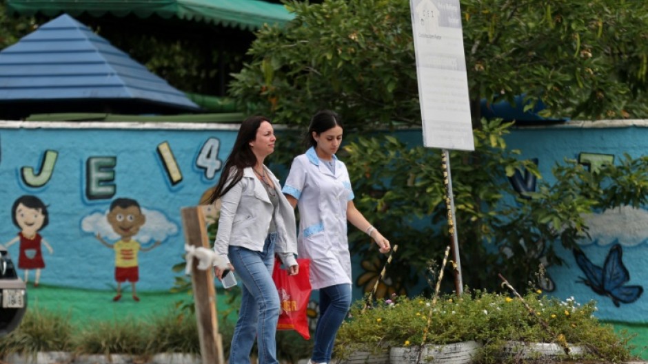 Women walk outside the preschool where an attacker killed four children in Blumenau in   southern Brazil