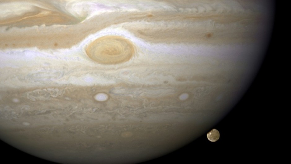 The moon Ganymede lurks behind the gas giant Jupiter in a Hubble telescope image from 2008