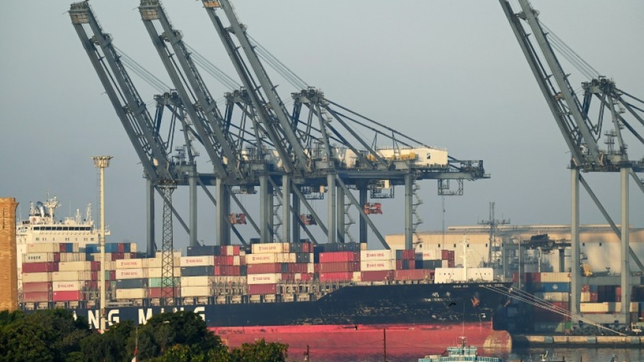 Shipping containers are seen stacked on a ship at port in Karachi on April 6, 2023. Pakistan has only enough forex reserves to pay for a month of imports