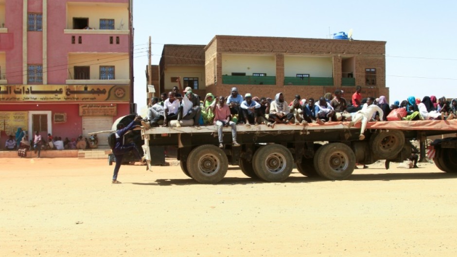 Civilians fleeing street battles on the back of a truck in southern Khartoum