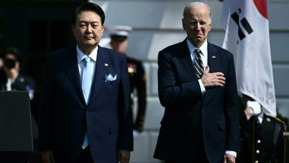 US President Joe Biden and South Korean President Yoon Suk Yeol listen to the national anthems at the White House