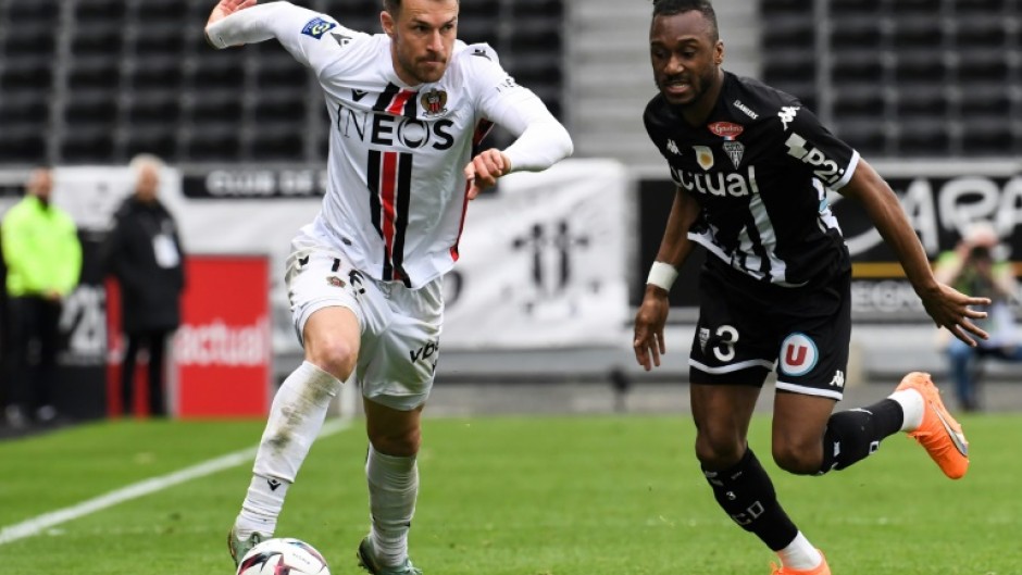 Aaron Ramsey (L) runs past Angers defender Souleyman Doumbia in Ligue 1