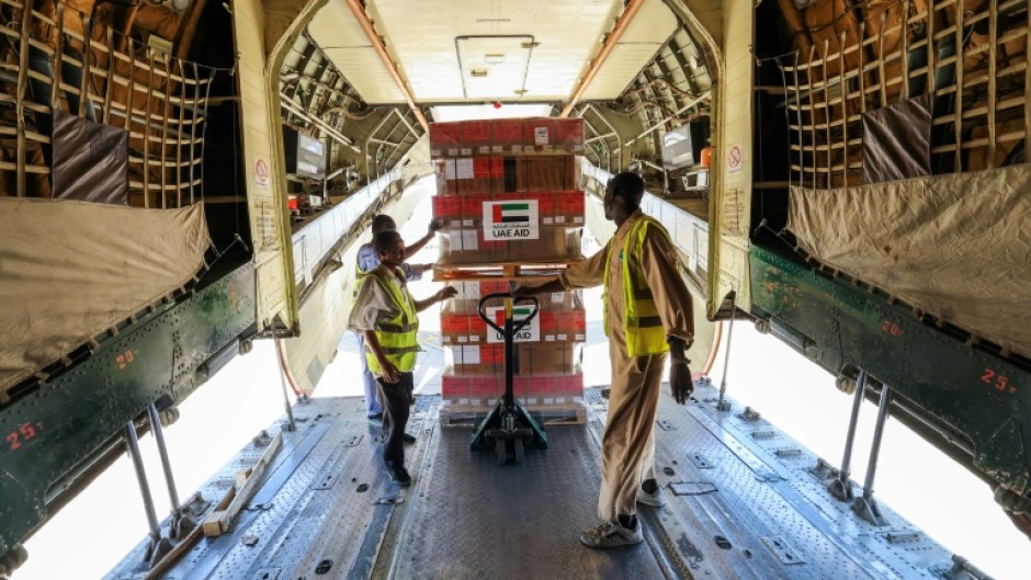 Workers offload WHO and UAEAID aid supplies from a plane in Port Sudan