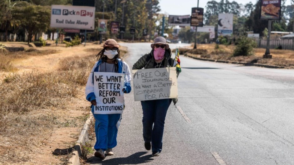 Dangarembga (L) and colleague Julie Barnes hold placards during their 2020 anti-corruption protest in Harare