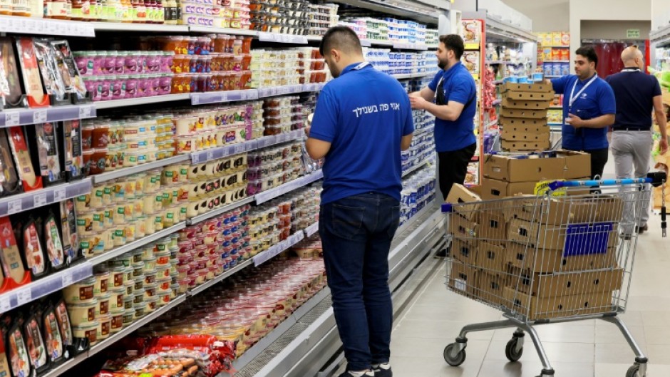 Employees of the Carrefour Hypermarket in Raanana, Israel, stock shelves before the French firm's opening in the country